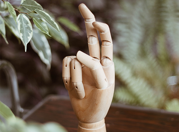 A wooden figure of a hand with two bent fingers
