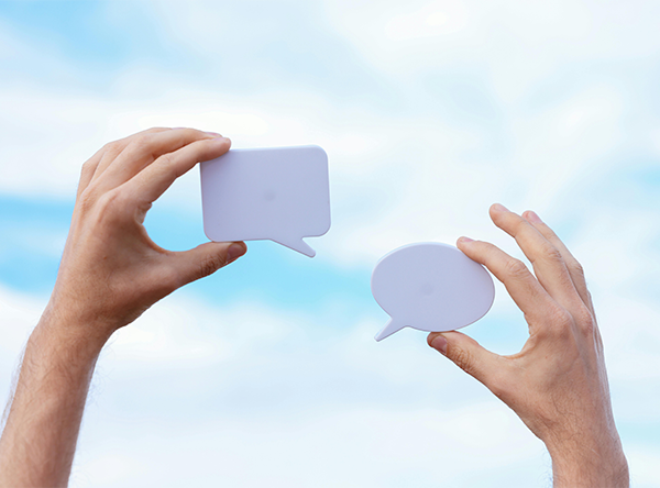 two hands hold up blocks shaped like speech bubbles two hands hold up blocks shaped like speech bubbles