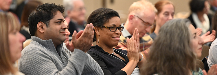 Several people sitting and applauding 