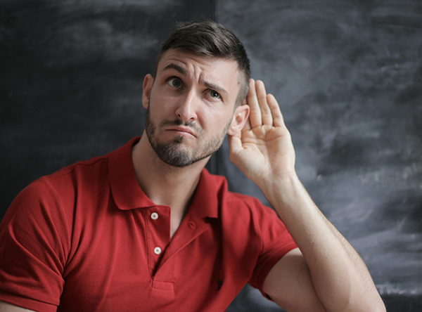 a person cups their hand around their ear