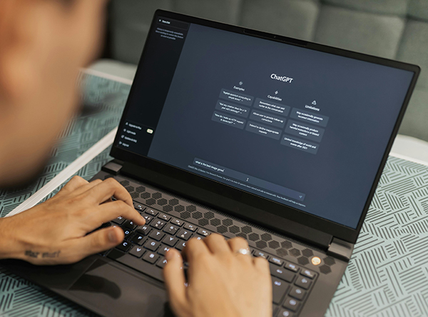 a person types on a laptop that displays the ChatGPT website