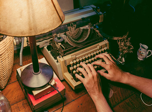 Hands typing on typewriter
