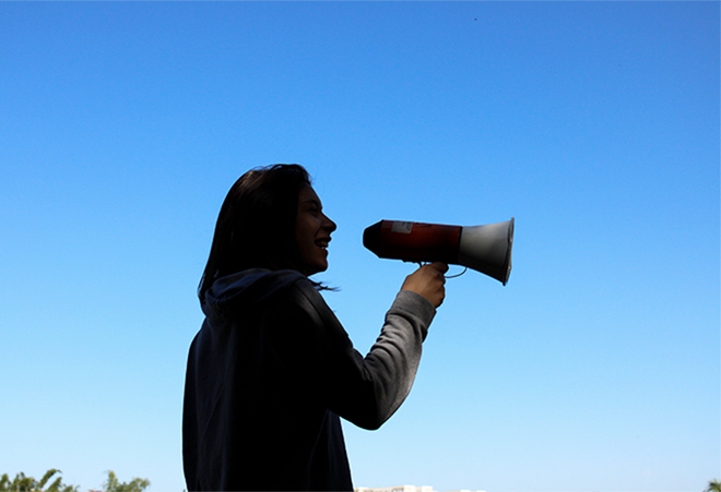 A person stands with a megaphone