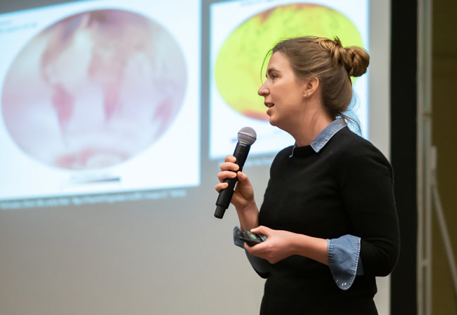 person with microphone presenting at a conference