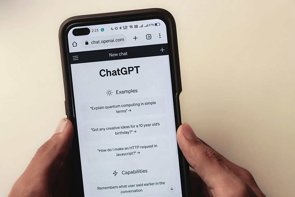 A phone screen displays the ChatGPT website