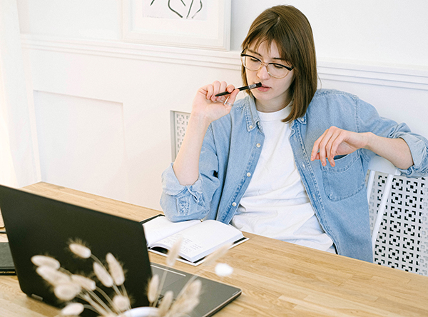 Woman thinking in front of laptop