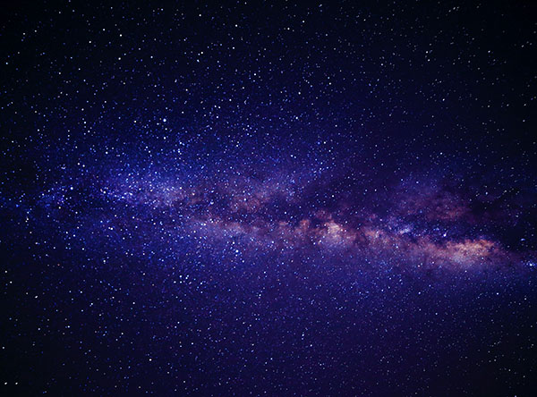 The purplish blue milky way galaxy as it appears in the night sky
