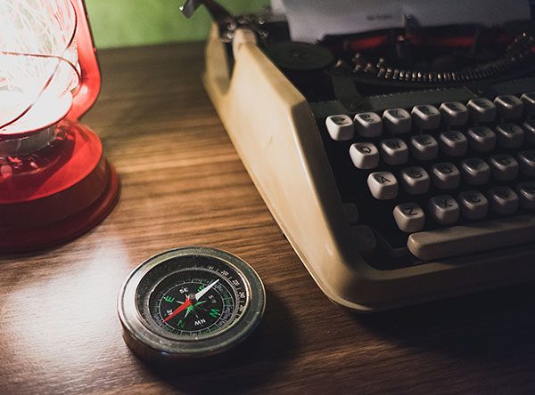 Compass next to a typewriter 