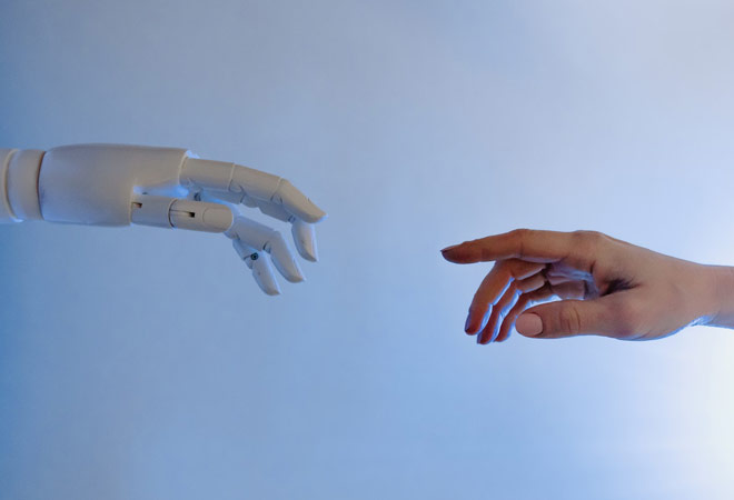 human hand and robotic hand reaching towards each other