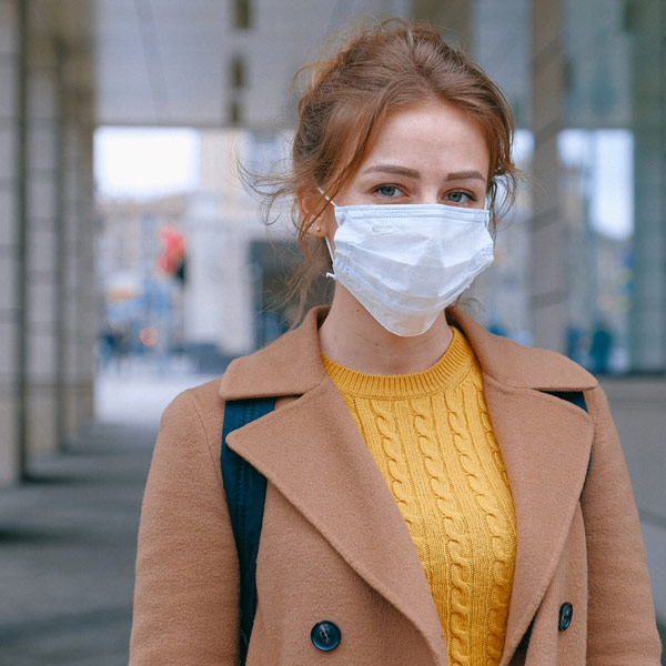 person wearing medical mask and coat